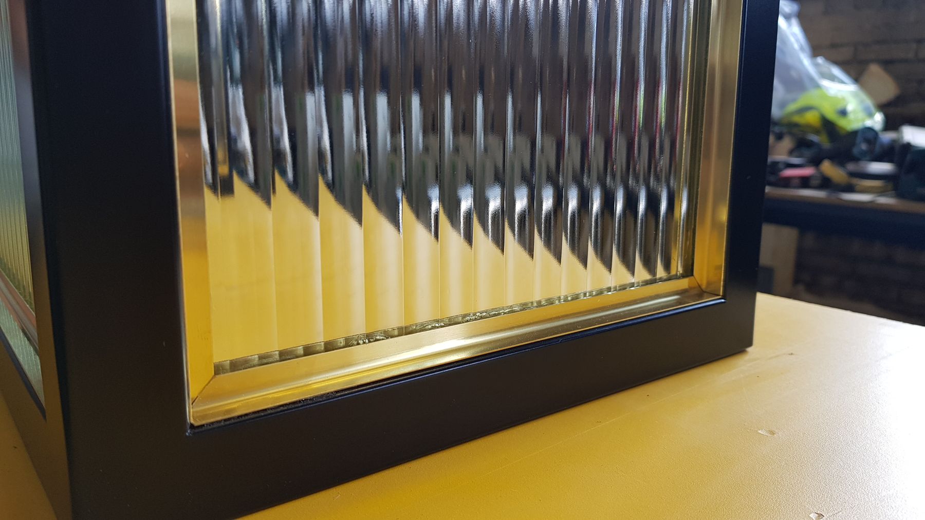 Riffelklaasiga vitriini detail, must raam ja messing